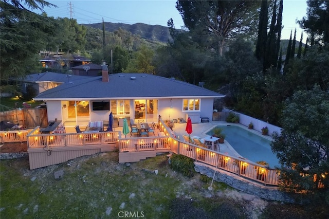 7235 Estepa Dr, Tujunga, CA 91042 - back of property with a fenced backyard, a chimney, a wooden deck, and outdoor lounge area