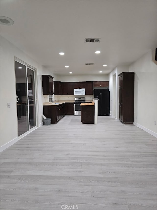 1416 Plaza Way, Perris, CA 92570 - kitchen featuring stainless steel range, white microwave, light wood-style floors, freestanding refrigerator, and open floor plan