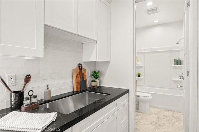 1108 Stanford Ave, Redondo Beach, CA 90278 - kitchen with white cabinetry, decorative backsplash, dark countertops, recessed lighting, and marble finish flooring