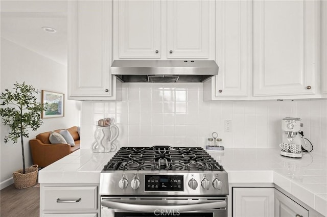 1108 Stanford Ave, Redondo Beach, CA 90278 - kitchen with stainless steel gas range oven, under cabinet range hood, white cabinets, tile countertops, and backsplash