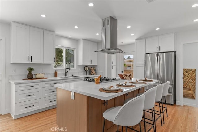 1848 Lave Ave, Long Beach, CA 90815 - kitchen with appliances with stainless steel finishes, island range hood, a sink, light wood-type flooring, and a center island