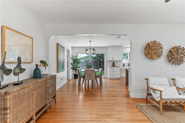 1848 Lave Ave, Long Beach, CA 90815 - dining room featuring arched walkways, light wood finished floors, baseboards, and a chandelier