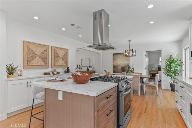 1848 Lave Ave, Long Beach, CA 90815 - kitchen featuring island range hood, stainless steel gas range oven, a center island, a breakfast bar area, and white cabinets