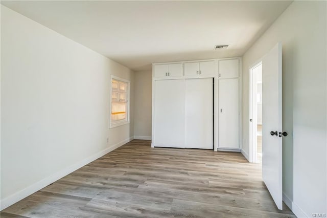 390 E 4th St, San Bernardino, CA 92410 - unfurnished bedroom featuring baseboards, light wood-style floors, and a closet