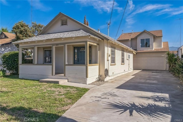 390 E 4th St, San Bernardino, CA 92410 - view of front facade with driveway, a porch, a front lawn, a shingled roof, and an attached garage