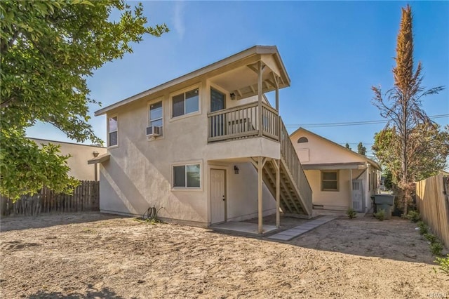 390 E 4th St, San Bernardino, CA 92410 - rear view of property with a fenced backyard, stairs, and stucco siding