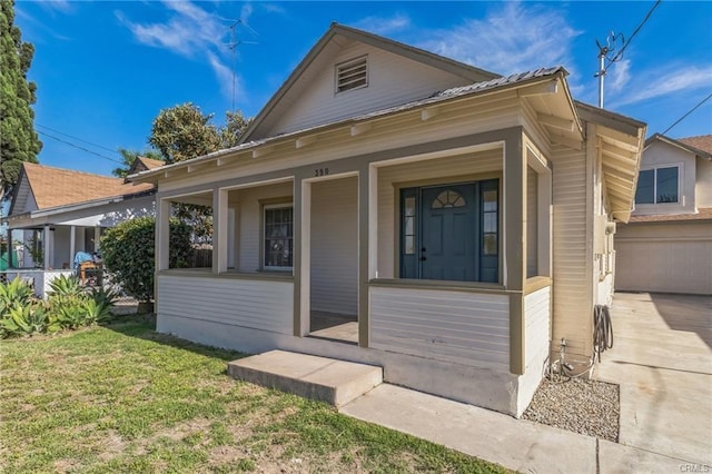 390 E 4th St, San Bernardino, CA 92410 - view of front of house with covered porch, a front yard, concrete driveway, and metal roof