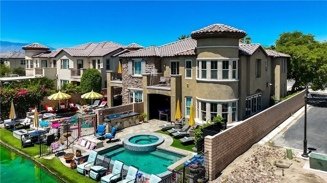 43228 Bacino Ct, Indio, CA 92203 - back of property featuring stucco siding, a balcony, a patio, a tile roof, and a pool with connected hot tub