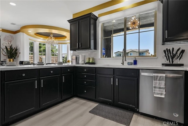 43228 Bacino Ct, Indio, CA 92203 - kitchen with stainless steel dishwasher, a sink, light wood-style flooring, a chandelier, and dark cabinetry