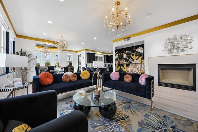 43228 Bacino Ct, Indio, CA 92203 - living area with a chandelier, a glass covered fireplace, recessed lighting, and ornamental molding