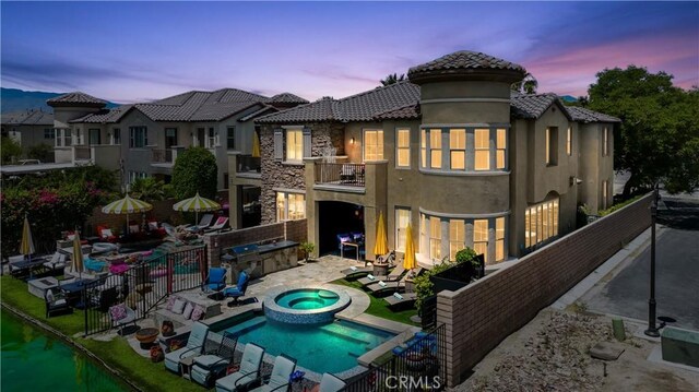 43228 Bacino Ct, Indio, CA 92203 - back of property at dusk with a balcony, a patio, stucco siding, area for grilling, and a tiled roof