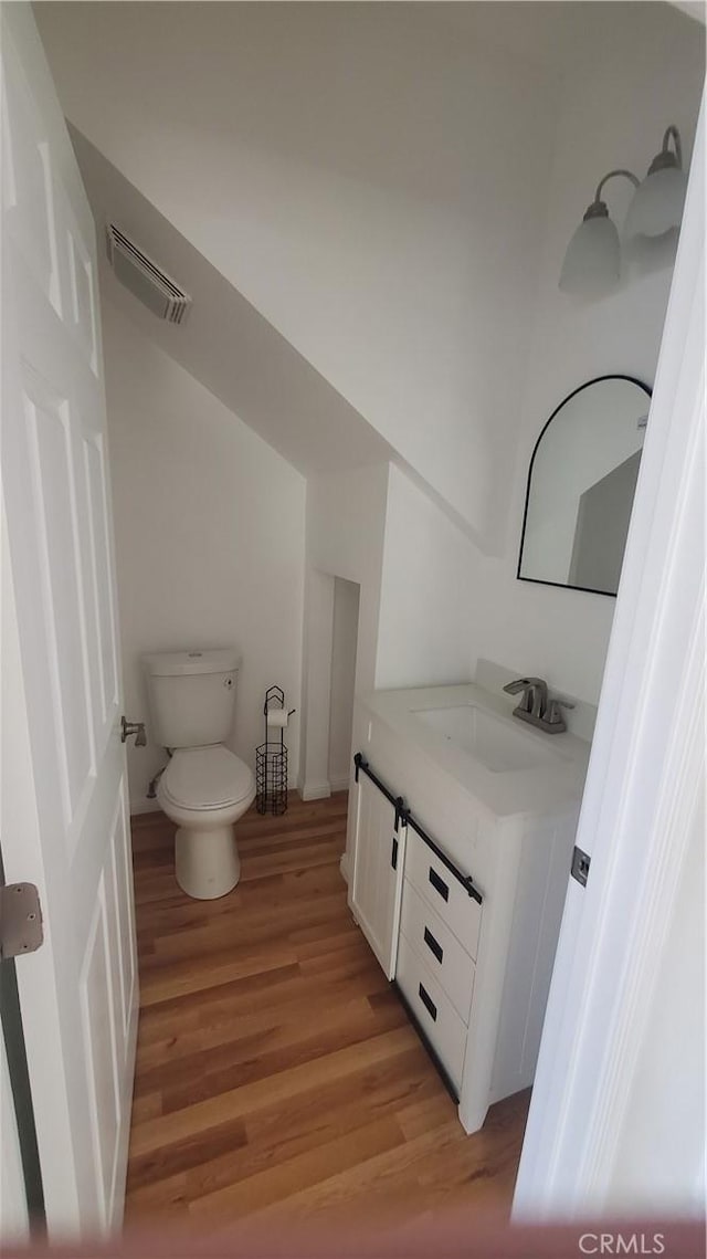 1330 W 48th St, Los Angeles, CA 90037 - bathroom featuring toilet, wood finished floors, and vanity