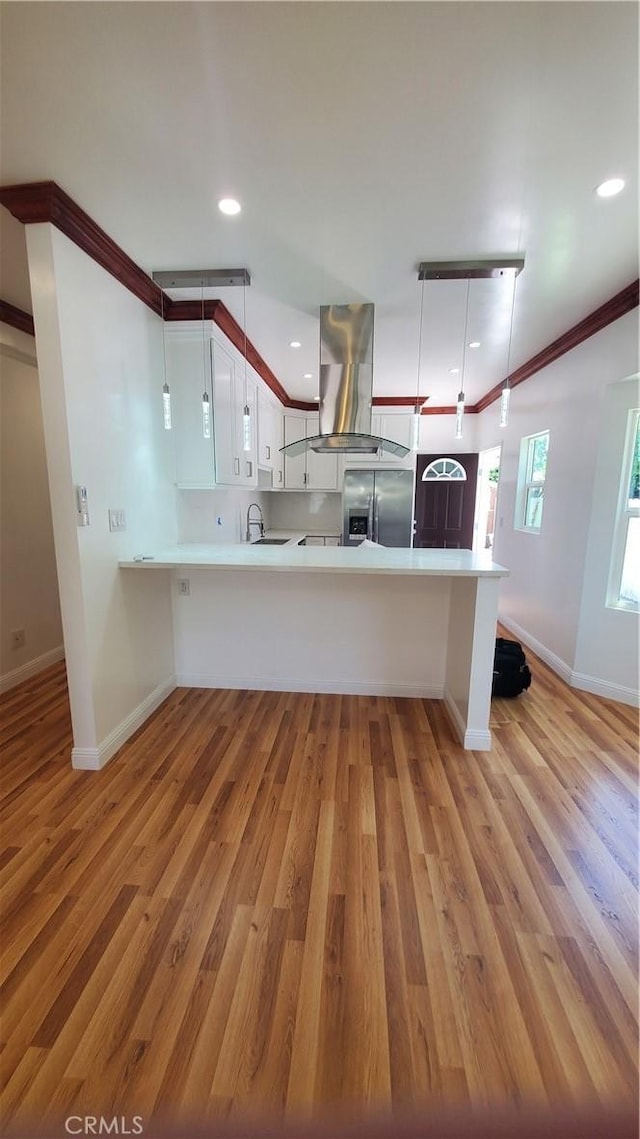 1330 W 48th St, Los Angeles, CA 90037 - kitchen featuring island range hood, stainless steel fridge with ice dispenser, a peninsula, baseboards, and ornamental molding