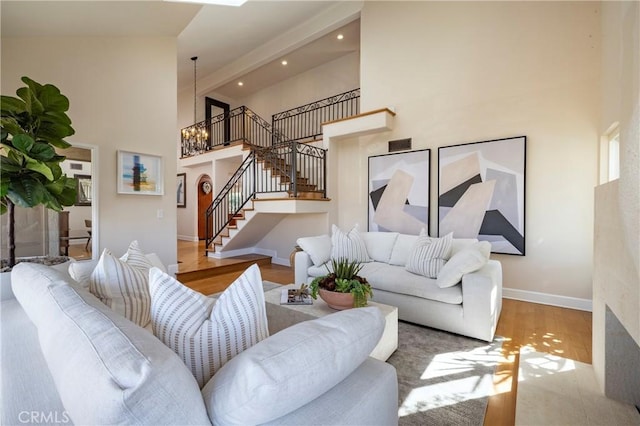 16561 Wanderer Ln, Huntington Beach, CA 92649 - living area featuring high vaulted ceiling, stairway, wood finished floors, baseboards, and a chandelier