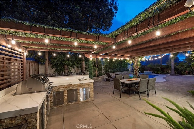 16561 Wanderer Ln, Huntington Beach, CA 92649 - patio at night featuring a patio area, a sink, area for grilling, a fenced backyard, and a pergola