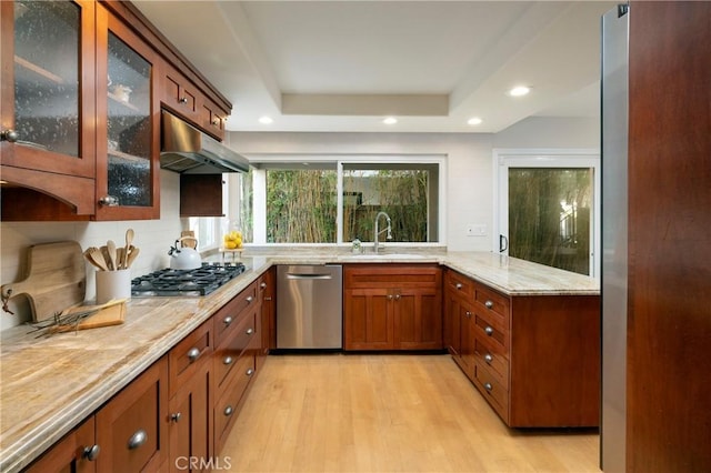 16561 Wanderer Ln, Huntington Beach, CA 92649 - kitchen featuring stainless steel appliances, a sink, under cabinet range hood, light stone counters, and light wood-style flooring