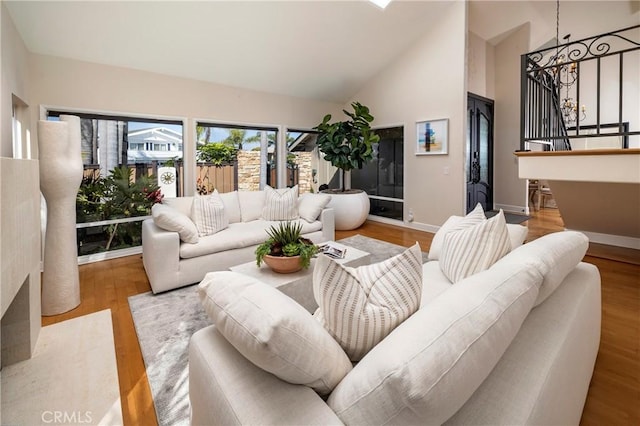 16561 Wanderer Ln, Huntington Beach, CA 92649 - living room featuring stairs, high vaulted ceiling, baseboards, and wood finished floors