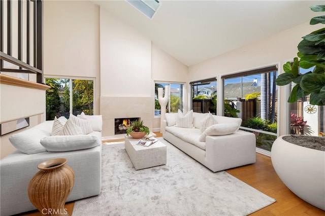 16561 Wanderer Ln, Huntington Beach, CA 92649 - living room featuring high vaulted ceiling, wood finished floors, and a warm lit fireplace