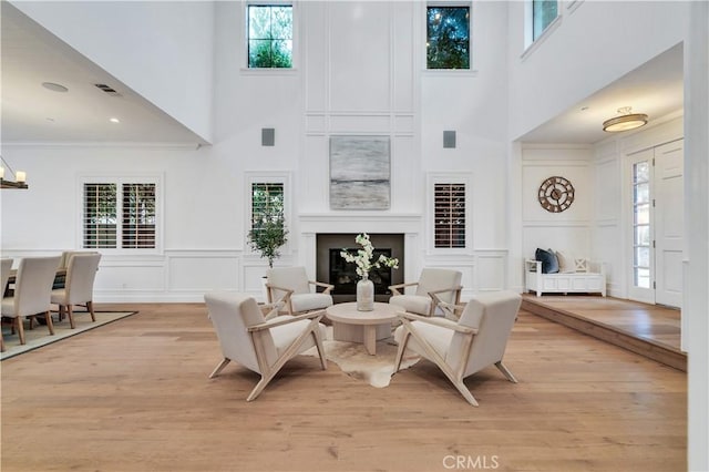 2001 Oak Ave, Manhattan Beach, CA 90266 - living area with a high ceiling, a decorative wall, a glass covered fireplace, light wood-style floors, and plenty of natural light