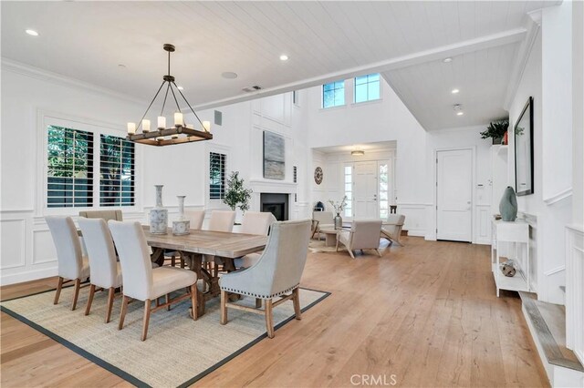 2001 Oak Ave, Manhattan Beach, CA 90266 - dining space with light wood finished floors, a chandelier, a fireplace, a decorative wall, and wainscoting