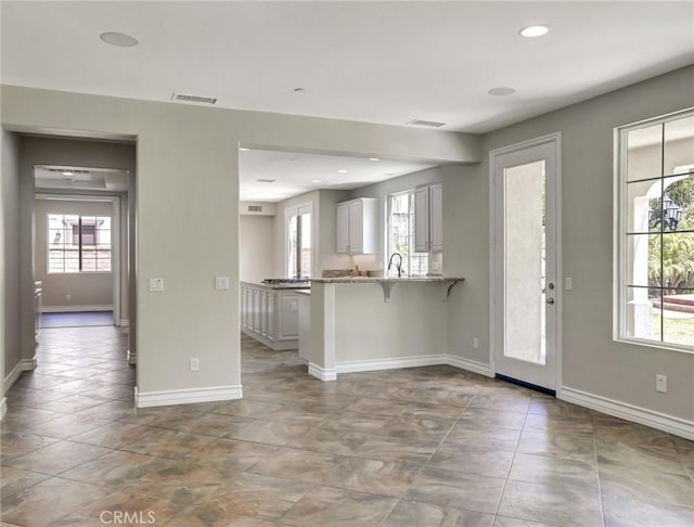 2237 Sageleaf Cir, Corona, CA 92882 - kitchen with healthy amount of natural light, baseboards, light stone countertops, and recessed lighting
