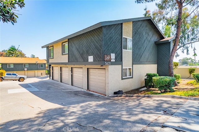 5631 Lake Park Way Unit 2, La Mesa, CA 91942 - view of side of home with driveway, stucco siding, and a garage