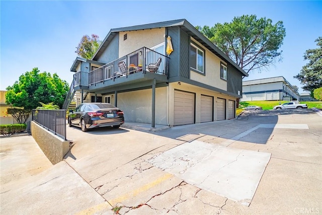 5631 Lake Park Way Unit 2, La Mesa, CA 91942 - view of front facade featuring stairway, a garage, stucco siding, driveway, and a balcony