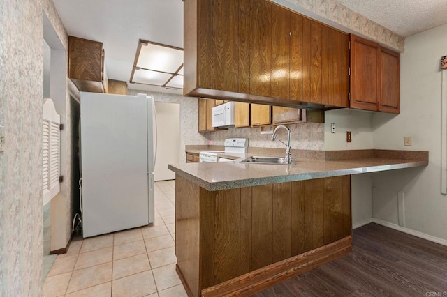 9336 Nalini Ct, Santee, CA 92071 - kitchen featuring white appliances, a peninsula, brown cabinets, and light tile patterned flooring