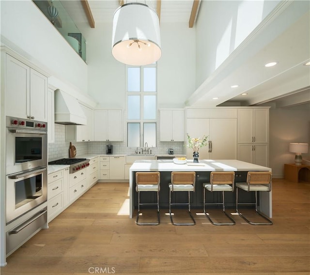 2104 Flournoy Rd, Manhattan Beach, CA 90266 - kitchen with custom exhaust hood, a high ceiling, stainless steel appliances, a warming drawer, and a sink