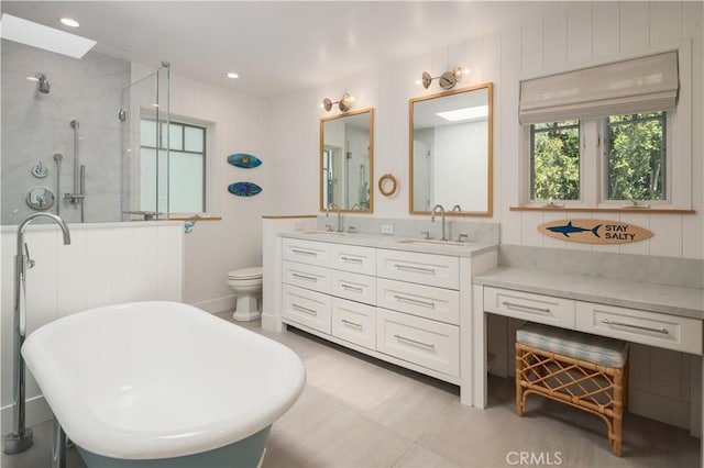 2104 Flournoy Rd, Manhattan Beach, CA 90266 - bathroom featuring a stall shower, double vanity, a soaking tub, toilet, and a skylight