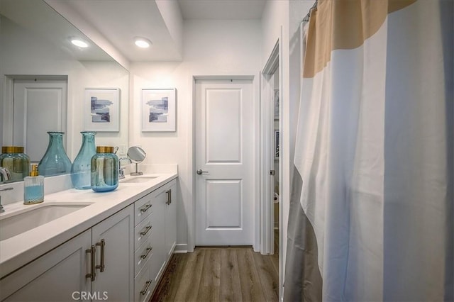 9630 Nova Pl, Rancho Cucamonga, CA 91730 - bathroom featuring double vanity, wood finished floors, and recessed lighting