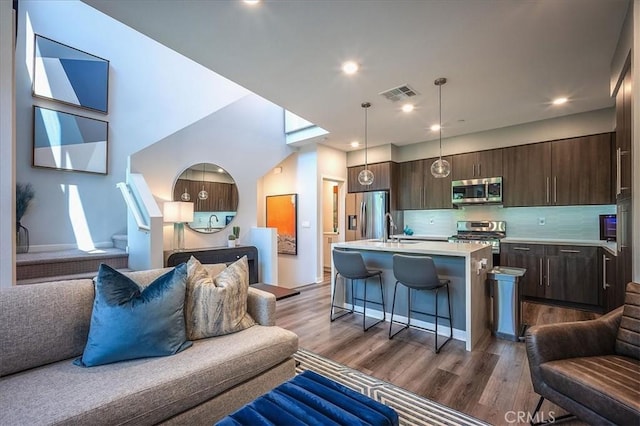 9630 Nova Pl, Rancho Cucamonga, CA 91730 - kitchen with open floor plan, appliances with stainless steel finishes, dark brown cabinetry, light countertops, and a sink