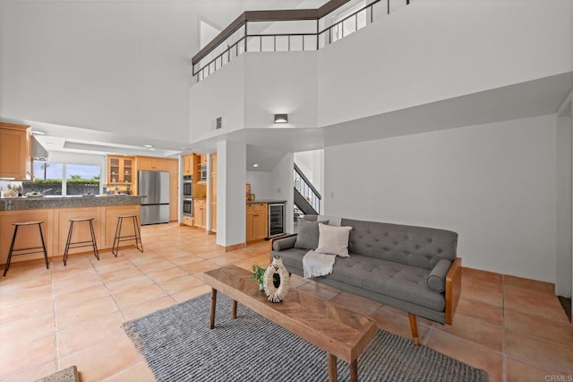 1033 Via Mil Cumbres, Solana Beach, CA 92075 - living room with beverage cooler, light tile patterned floors, a high ceiling, and stairway