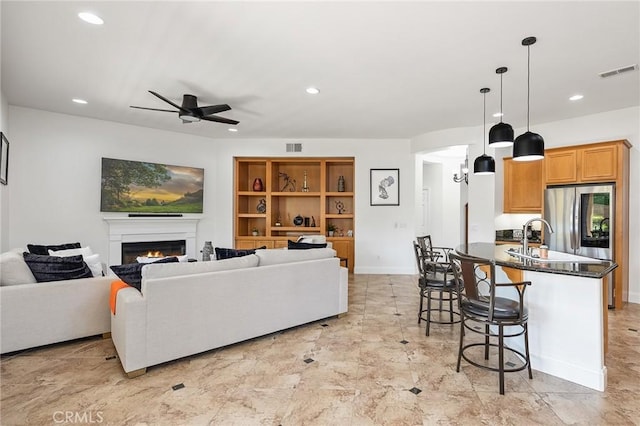 44774 Pride Mountain St, Temecula, CA 92592 - living area featuring a ceiling fan, a lit fireplace, recessed lighting, and baseboards