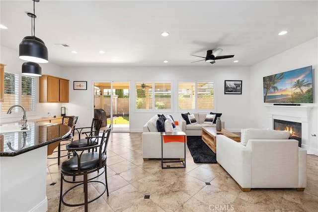 44774 Pride Mountain St, Temecula, CA 92592 - living area with healthy amount of natural light, ceiling fan, recessed lighting, a glass covered fireplace, and baseboards