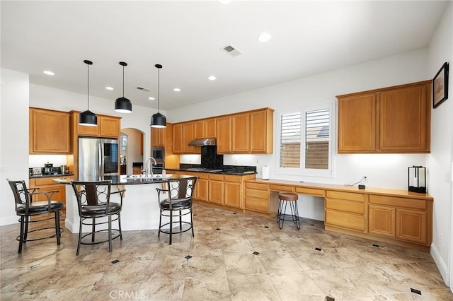 44774 Pride Mountain St, Temecula, CA 92592 - kitchen with appliances with stainless steel finishes, a breakfast bar area, a sink, dark countertops, and an island with sink