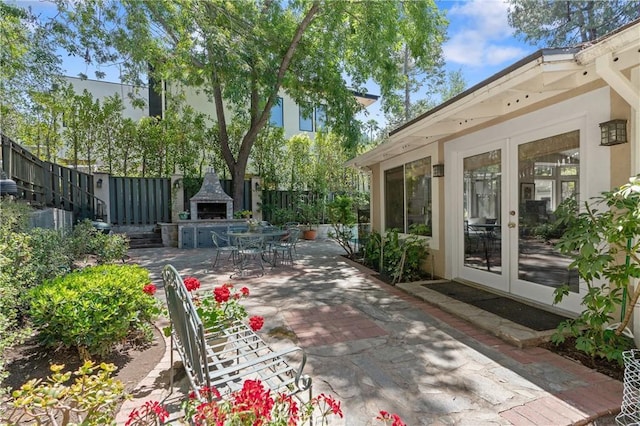 3818 Hayvenhurst Ave, Encino, CA 91436 - fenced backyard with an outdoor fireplace, a patio area, and french doors