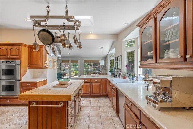 3818 Hayvenhurst Ave, Encino, CA 91436 - kitchen with wooden counters, stainless steel appliances, brown cabinets, and glass insert cabinets