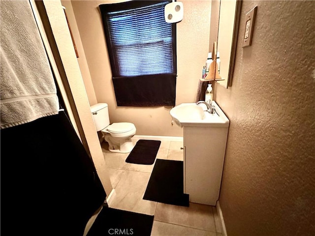 828 W 23rd St, Merced, CA 95340 - bathroom with tile patterned floors, vanity, toilet, a textured wall, and baseboards