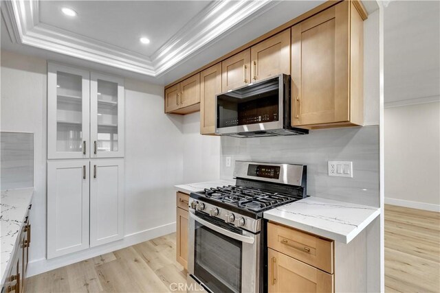 1425 Forest Glen Dr Unit 159, Hacienda Heights, CA 91745 - kitchen featuring appliances with stainless steel finishes, a raised ceiling, light wood-style flooring, baseboards, and ornamental molding