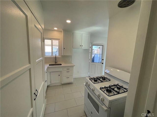 2221 Granada Ave, Long Beach, CA 90815 - kitchen featuring white range with gas stovetop, a sink, light tile patterned flooring, white cabinets, and recessed lighting