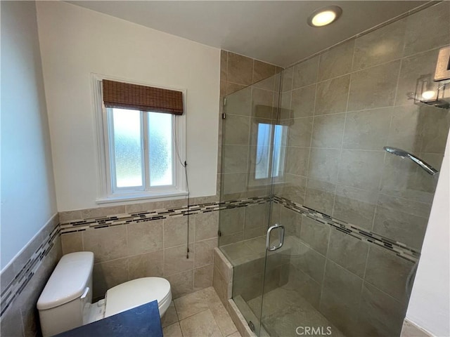2221 Granada Ave, Long Beach, CA 90815 - bathroom featuring toilet, tile walls, a shower stall, tile patterned floors, and wainscoting