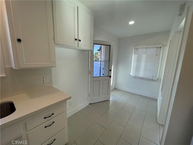 2221 Granada Ave, Long Beach, CA 90815 - kitchen featuring baseboards, light countertops, white cabinets, light tile patterned floors, and recessed lighting