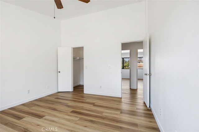 41586 Zinfandel Ave, Temecula, CA 92591 - unfurnished bedroom with light wood finished floors, baseboards, a ceiling fan, a spacious closet, and a towering ceiling