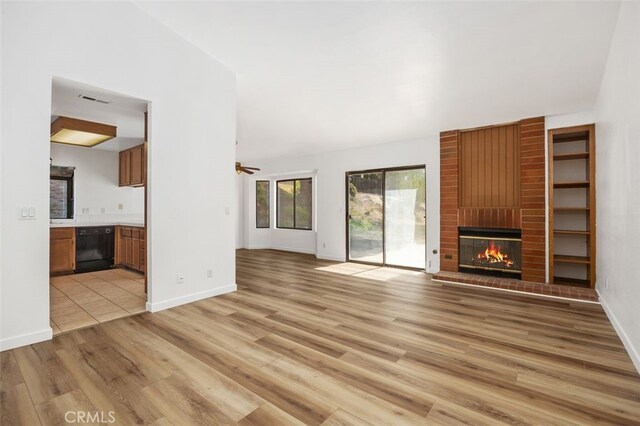 41586 Zinfandel Ave, Temecula, CA 92591 - unfurnished living room featuring light wood-style floors, a brick fireplace, ceiling fan, and baseboards
