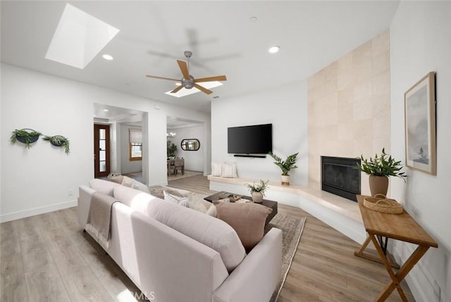 313 Myrtle Dr, Arroyo Grande, CA 93420 - living room with wood finished floors, a skylight, a tiled fireplace, recessed lighting, and ceiling fan