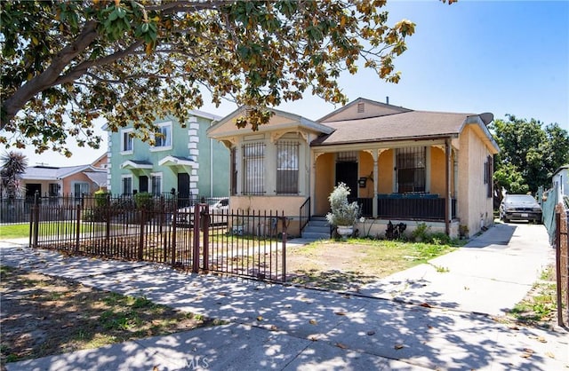 126 E 95th St, Los Angeles, CA 90003 - view of front of house featuring covered porch, a fenced front yard, and stucco siding