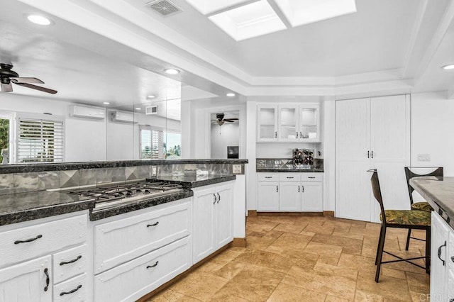 1923 Hidden Mesa Rd, El Cajon, CA 92019 - kitchen with ceiling fan, stainless steel gas stovetop, a wall mounted AC, white cabinets, and glass insert cabinets