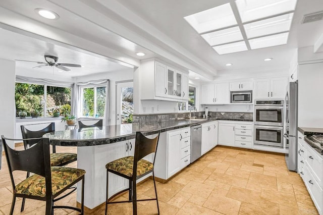 1923 Hidden Mesa Rd, El Cajon, CA 92019 - kitchen with stainless steel appliances, healthy amount of natural light, a peninsula, a breakfast bar, and recessed lighting