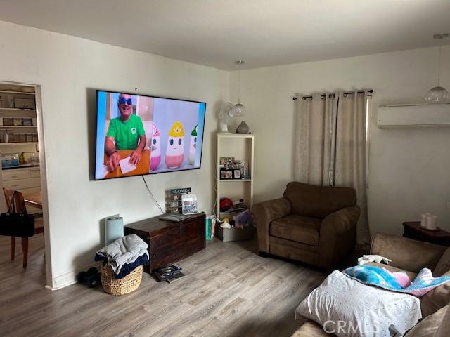 12758 5th St, Yucaipa, CA 92399 - living room with wood finished floors and a wall mounted air conditioner